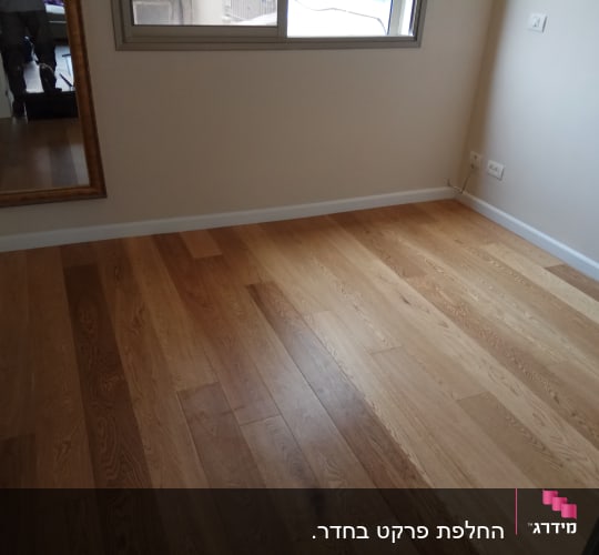 רצפת פרקט עץ בחדר ריק עם קירות בהירים